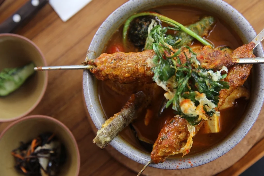 骨付き肉と野菜を盛り付けたスープカレー